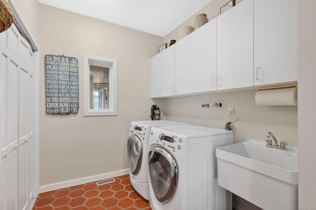 laundry area featuring a sink, cabinet space, independent washer and dryer, visible vents, and baseboards
