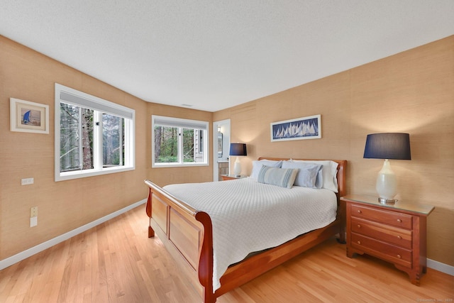 bedroom with light wood-style flooring and baseboards