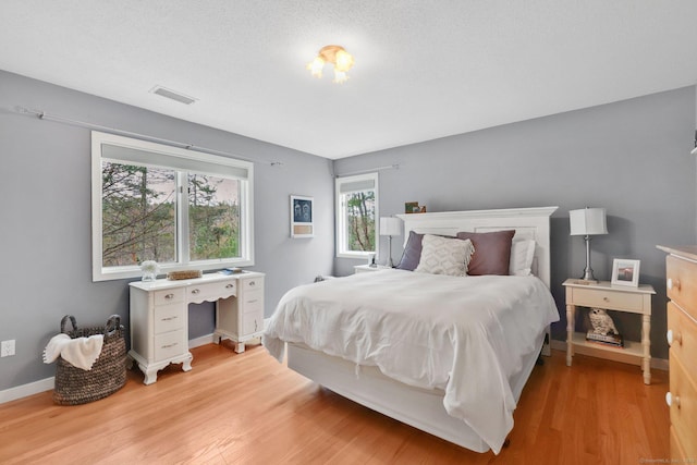 bedroom featuring baseboards, visible vents, and light wood-type flooring