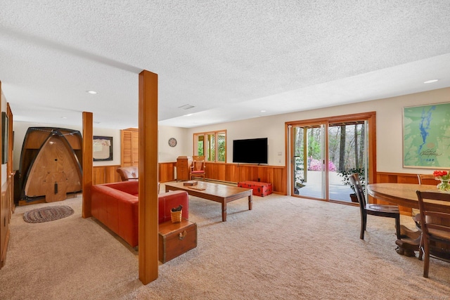 carpeted living room featuring wooden walls, recessed lighting, a textured ceiling, and wainscoting