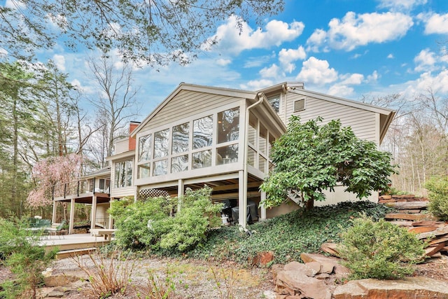 rear view of house with a deck and a sunroom
