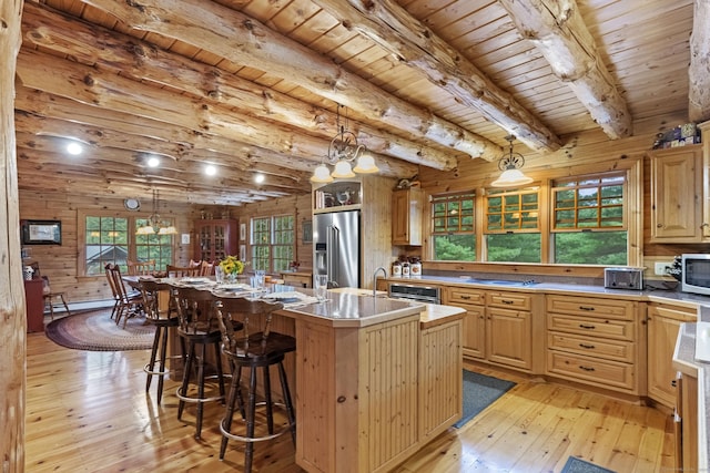 kitchen featuring light wood-type flooring, wood ceiling, high quality fridge, a center island with sink, and beam ceiling