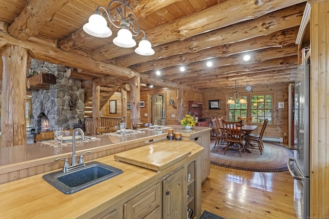 kitchen with wooden ceiling, a sink, hardwood / wood-style flooring, beamed ceiling, and wood counters