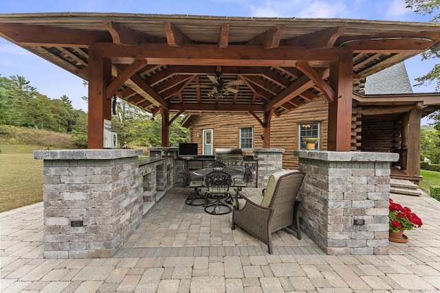 view of patio / terrace with an outdoor kitchen, outdoor dining area, and a gazebo