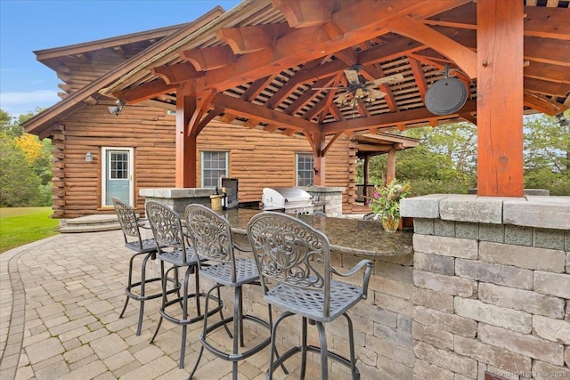 view of patio with a gazebo, exterior bar, a grill, an outdoor kitchen, and ceiling fan
