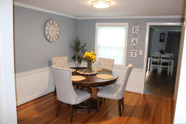 dining room with crown molding and wood finished floors