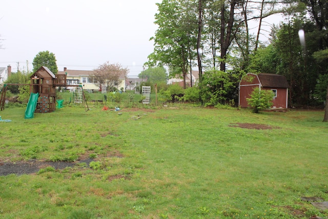 view of yard with a playground, an outbuilding, and a storage unit