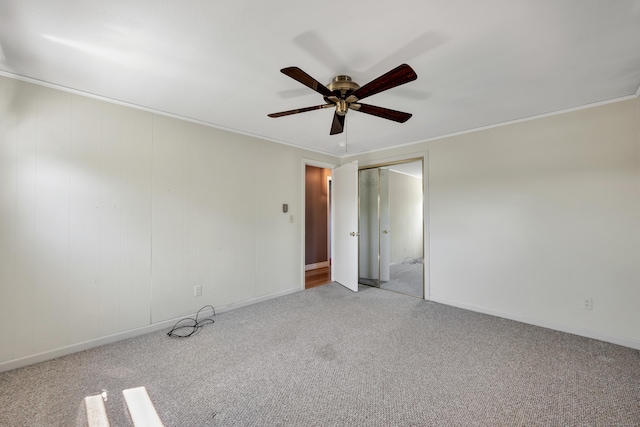 unfurnished room featuring carpet floors, ceiling fan, crown molding, and baseboards