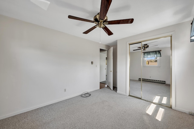 unfurnished bedroom featuring carpet floors, a closet, baseboards, baseboard heating, and a ceiling fan