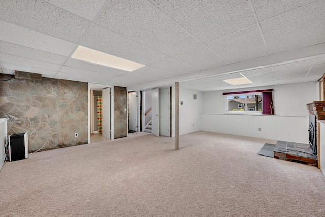 below grade area featuring stairway, carpet, and a drop ceiling