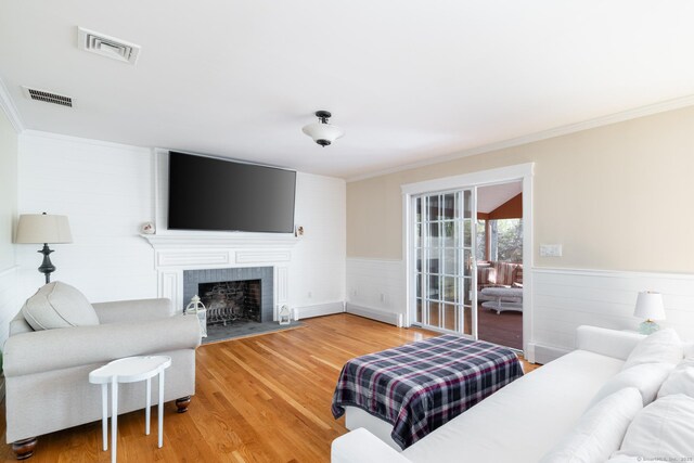 114 Cobbler Ln, Southbury, CT 06488 - living area with light wood-style floors, a wainscoted wall, crown molding, and visible vents