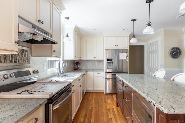 114 Cobbler Ln, Southbury, CT 06488 - kitchen with crown molding, under cabinet range hood, a sink, light wood finished floors, and stainless steel appliances