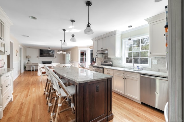 114 Cobbler Ln, Southbury, CT 06488 - kitchen with crown molding, a center island, a sink, open floor plan, and stainless steel appliances