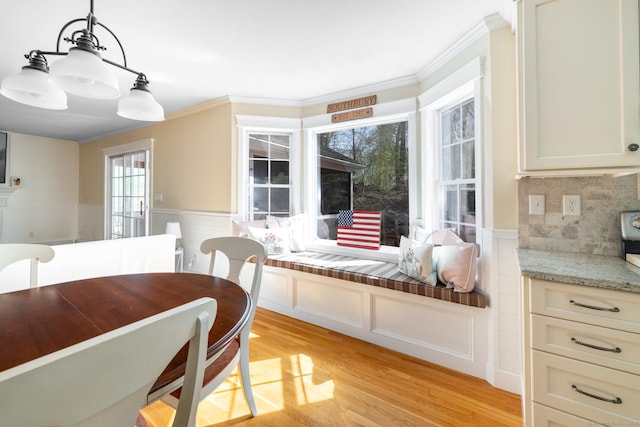 114 Cobbler Ln, Southbury, CT 06488 - dining space with a decorative wall, ornamental molding, wainscoting, and light wood-type flooring