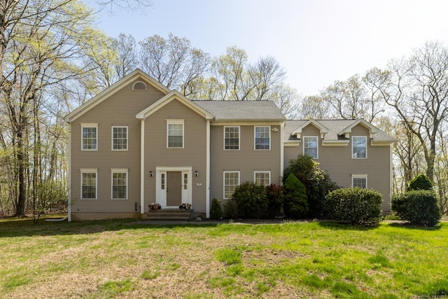 colonial-style house featuring a front yard