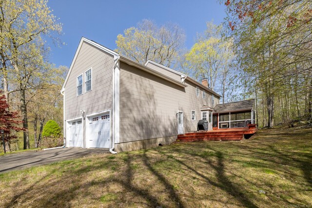 114 Cobbler Ln, Southbury, CT 06488 - view of property exterior with a chimney, a sunroom, aphalt driveway, a yard, and an attached garage
