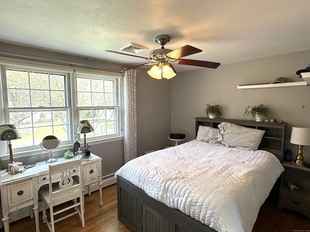 bedroom with visible vents, light wood finished floors, and a ceiling fan