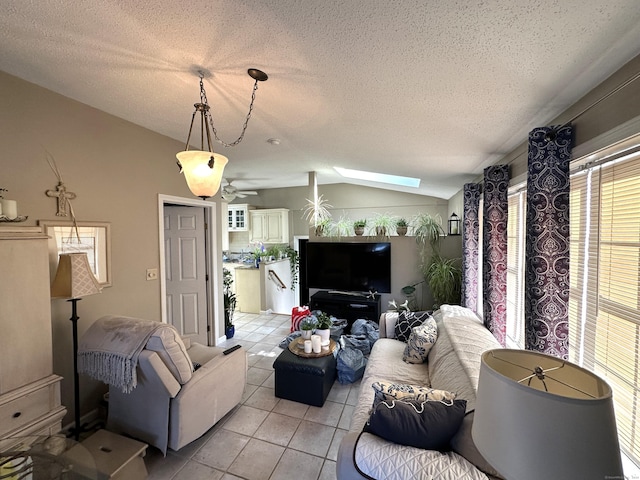 living area with lofted ceiling with skylight, a textured ceiling, and light tile patterned floors