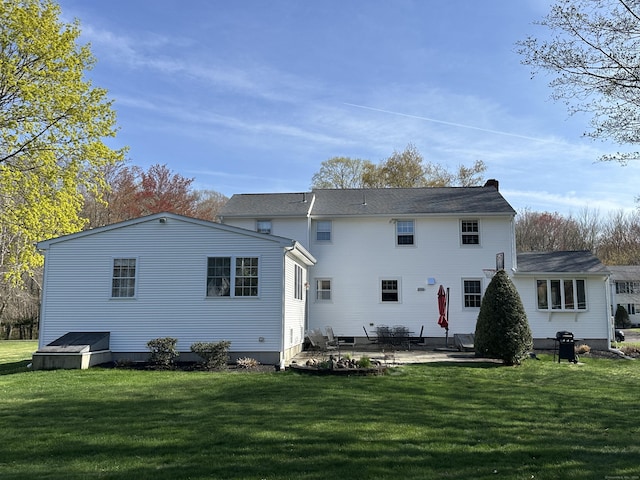 rear view of property with a patio and a yard