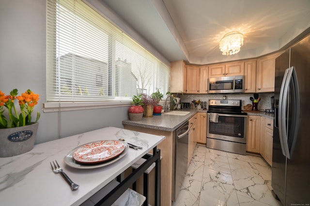 kitchen featuring light brown cabinetry, appliances with stainless steel finishes, a sink, marble finish floor, and decorative backsplash
