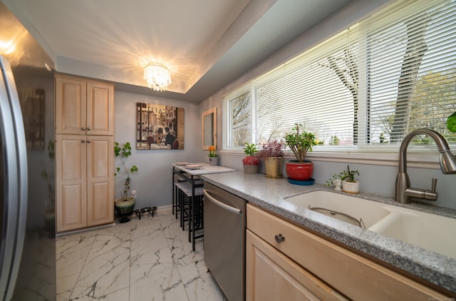 kitchen with stainless steel dishwasher, freestanding refrigerator, marble finish floor, a chandelier, and a sink