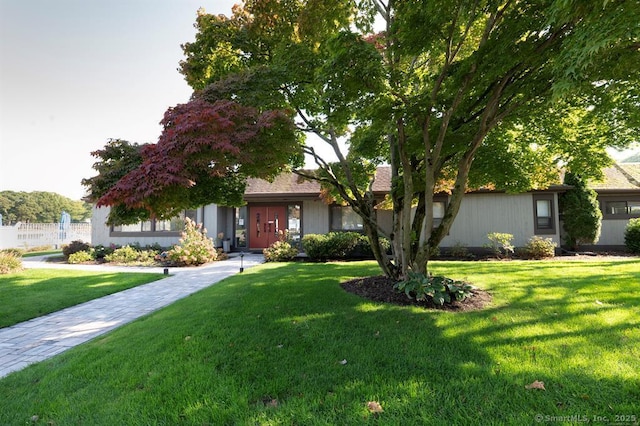view of front of property with fence and a front lawn