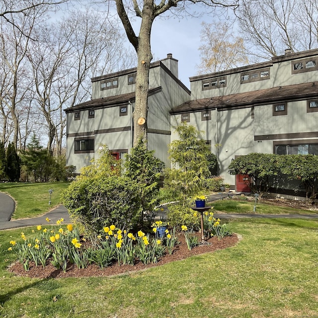 22 Harbour Vlg Unit A, Branford, CT 06405 - rear view of property featuring a chimney, a yard, and stucco siding
