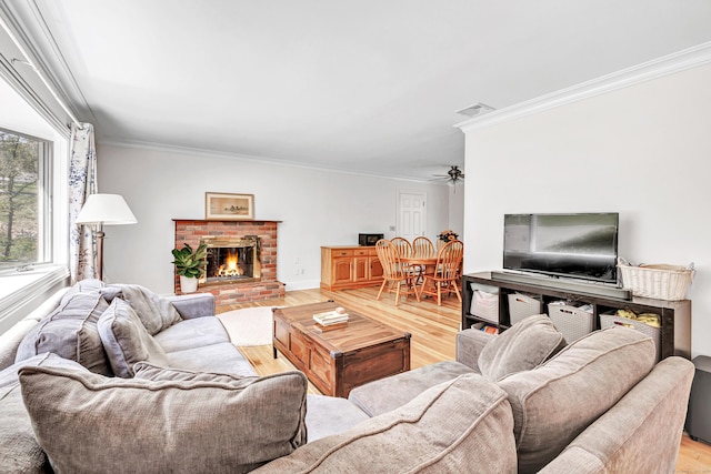 82 Village Dr, Shelton, CT 06484 - living area with ceiling fan, visible vents, crown molding, a brick fireplace, and light wood-style floors