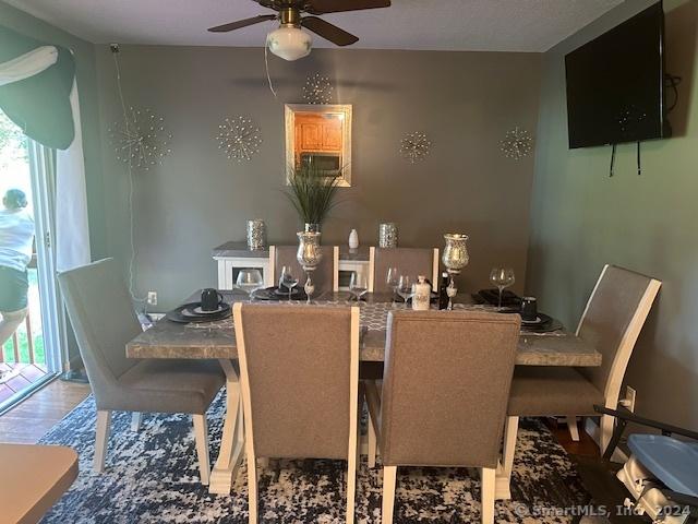 dining space with ceiling fan, wood finished floors, and plenty of natural light