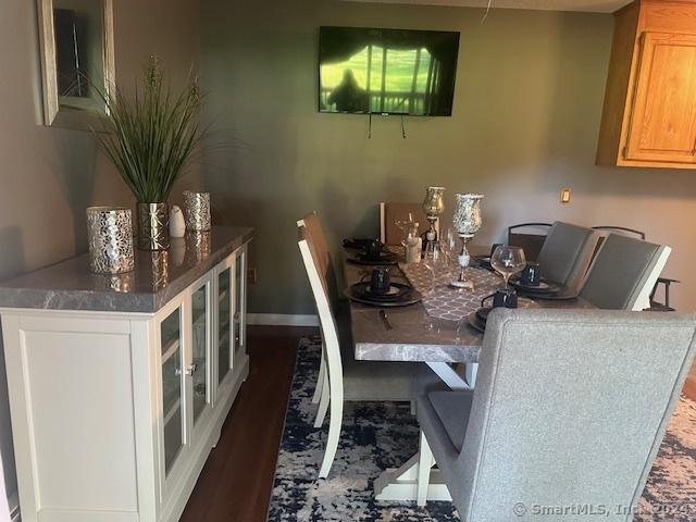 dining space with baseboards and wood finished floors