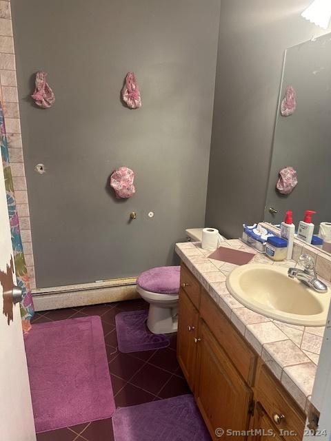 bathroom with tile patterned flooring, toilet, vanity, and a shower with shower curtain