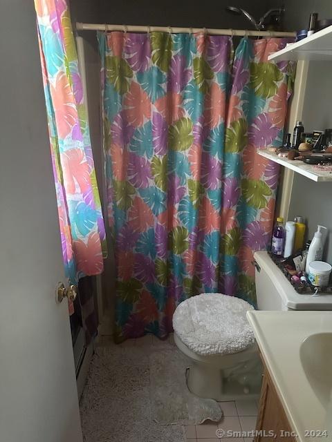 full bath featuring tile patterned flooring, toilet, vanity, and curtained shower
