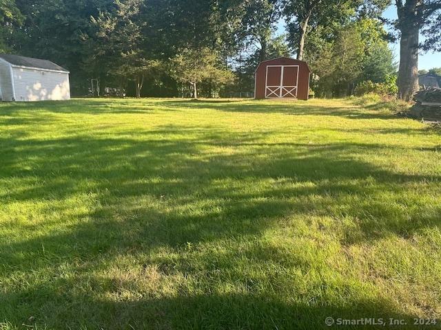 view of yard featuring an outbuilding and a storage shed