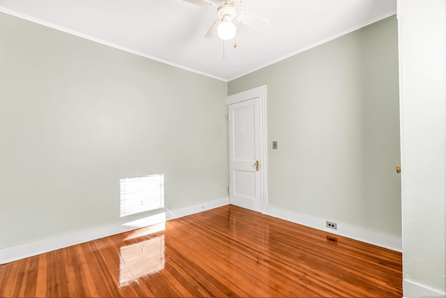 empty room featuring hardwood / wood-style flooring, baseboards, a ceiling fan, and crown molding