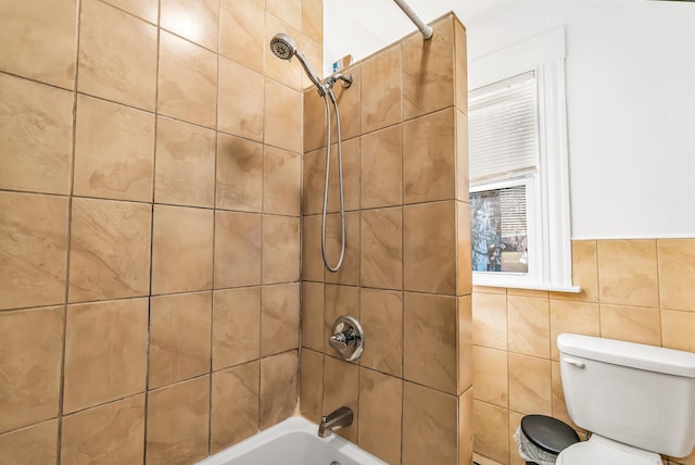 full bathroom featuring toilet, shower / tub combination, and tile walls