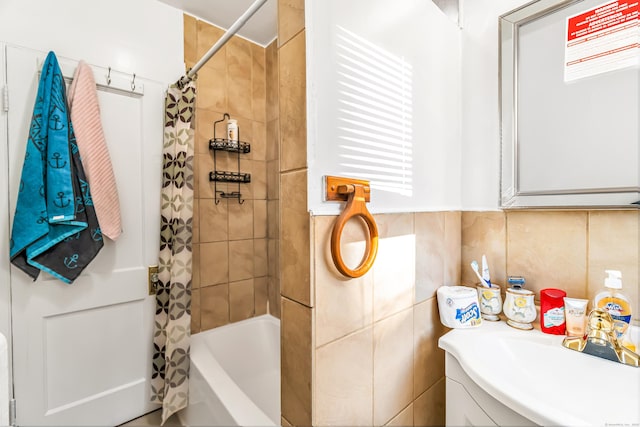 bathroom with shower / bath combo, a sink, and tile walls
