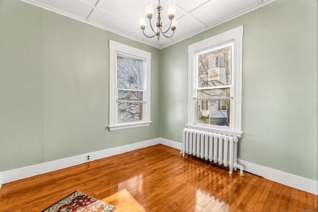 113 Bunker Hill Ave, Waterbury, CT 06708 - empty room featuring hardwood / wood-style flooring, ornamental molding, radiator, baseboards, and a notable chandelier