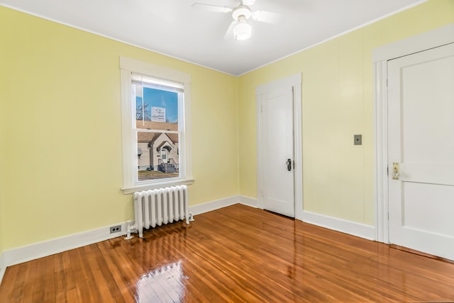 unfurnished room featuring wood-type flooring, baseboards, radiator heating unit, and ceiling fan
