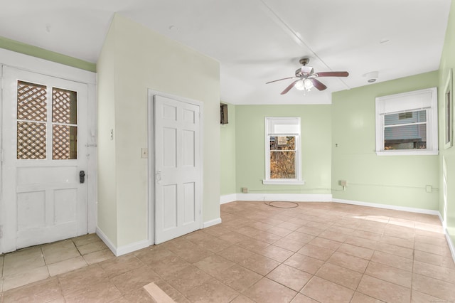 unfurnished room with baseboards, a ceiling fan, and light tile patterned floors