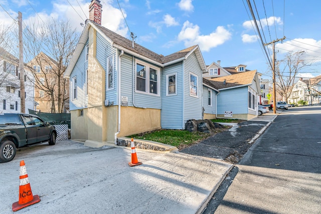 view of side of home with a chimney and a residential view