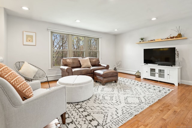 living area featuring recessed lighting, baseboards, a baseboard heating unit, and wood finished floors