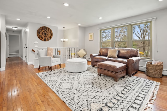 living area with baseboards, a baseboard radiator, a chandelier, recessed lighting, and hardwood / wood-style floors