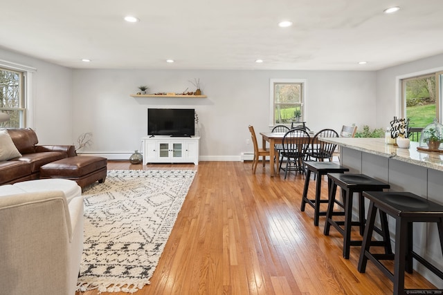 living room featuring recessed lighting, baseboards, and light wood-style floors