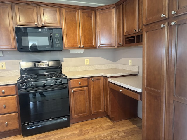 14 N Washington Ave, East Lyme, CT 06357 - kitchen featuring black appliances, light wood-style floors, light countertops, and brown cabinetry