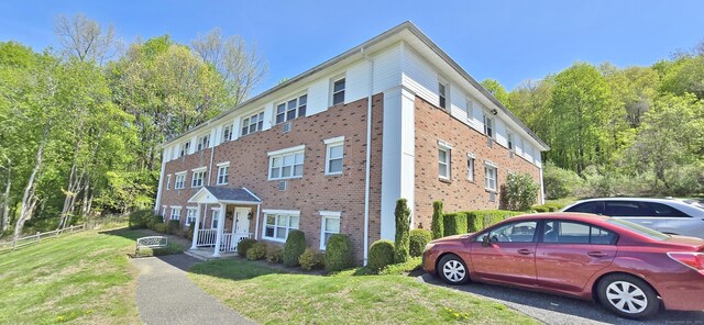 view of side of property with brick siding and a yard