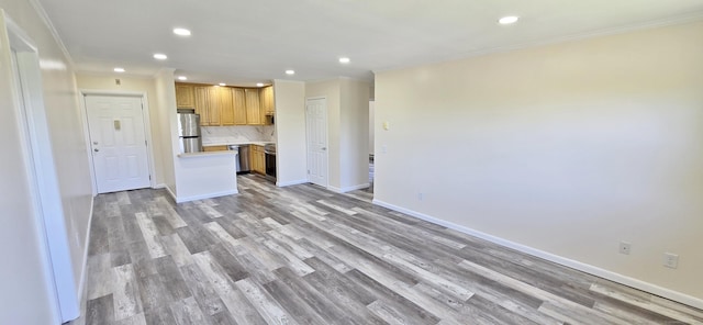 kitchen featuring freestanding refrigerator, crown molding, decorative backsplash, and light countertops
