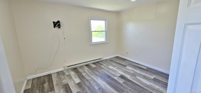 empty room with baseboards, a baseboard heating unit, and wood finished floors