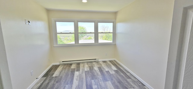 spare room featuring wood finished floors, recessed lighting, baseboards, and a baseboard heating unit