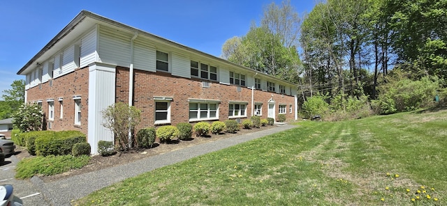 exterior space featuring brick siding and a yard