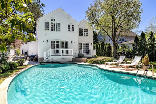 outdoor pool featuring a patio and a deck
